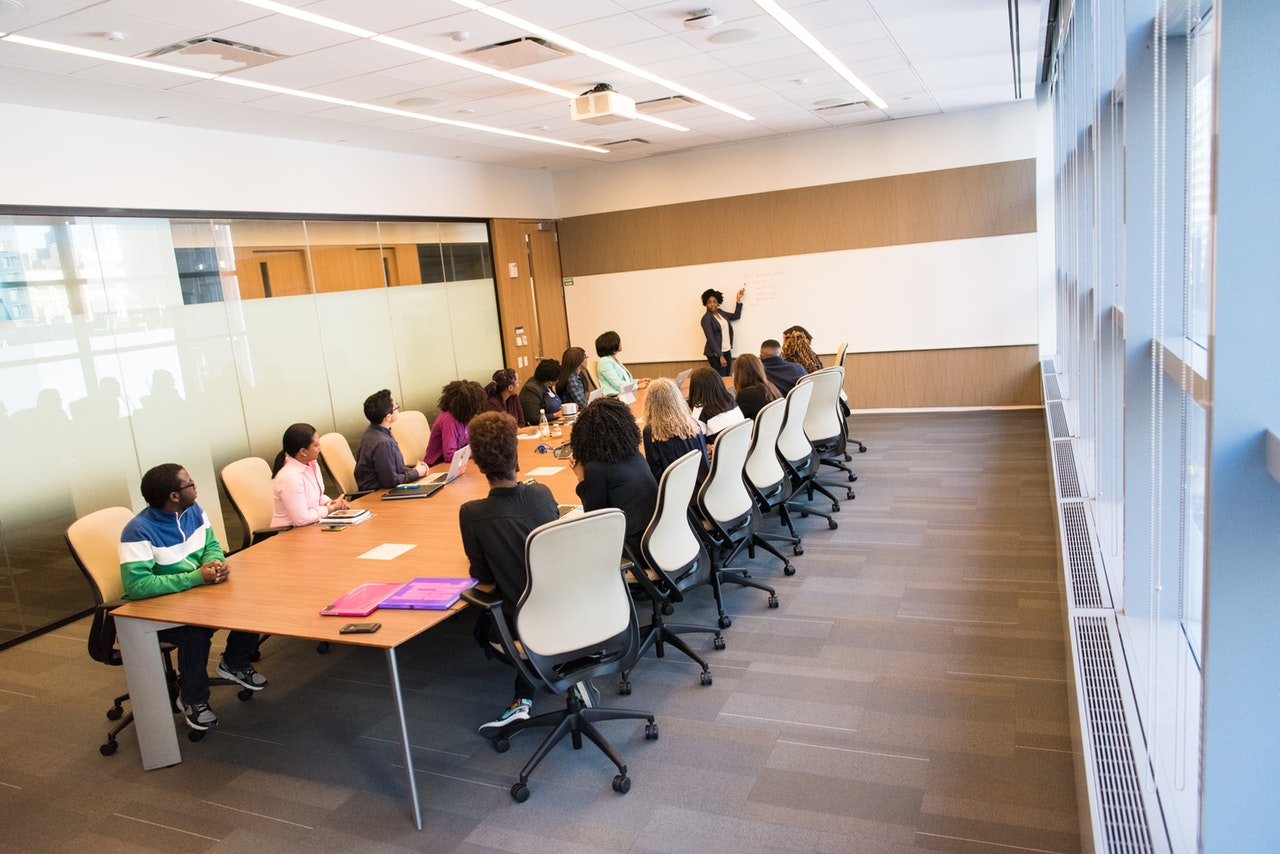 Reunião de equipe em uma sala de escritório moderna, com pessoas colaborando.